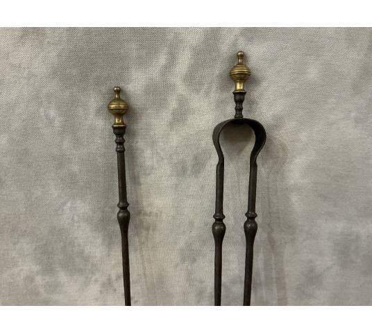 A 19th-century iron and bronze fireplace set consisting of a shovel and tongs.