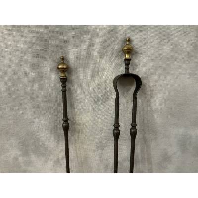 A 19th-century iron and bronze fireplace set consisting of a shovel and tongs.