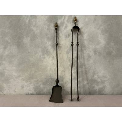 A 19th-century iron and bronze fireplace set consisting of a shovel and tongs.
