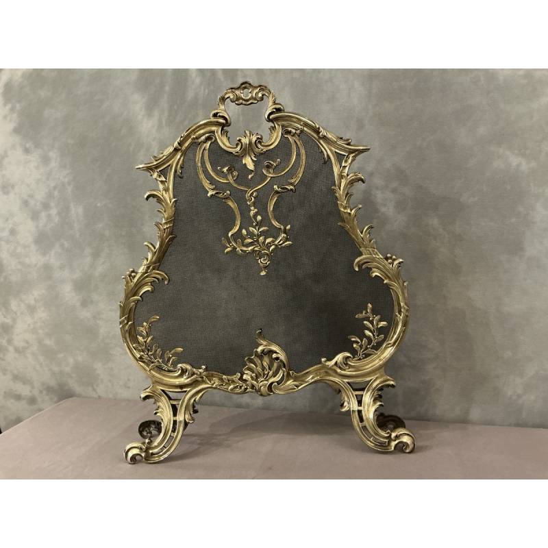 Polished bronze fireplace screen dating from the 19th century in the Louis XV style