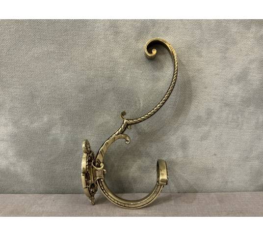 Polished and varnished bronze coat hook from the 19th century