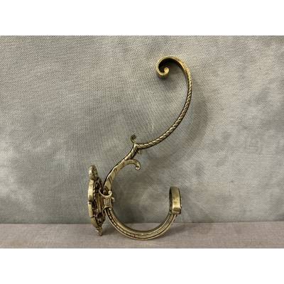 Polished and varnished bronze coat hook from the 19th century