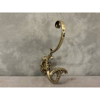 Polished and varnished bronze coat hook from the 19th century