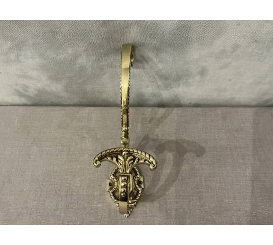 Polished and varnished bronze coat hook from the 19th century
