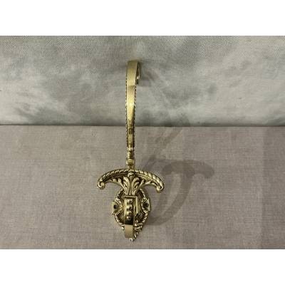 Polished and varnished bronze coat hook from the 19th century