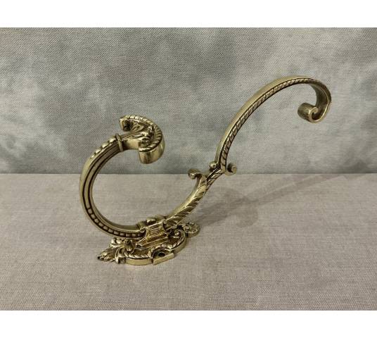 Polished and varnished bronze coat hook from the 19th century