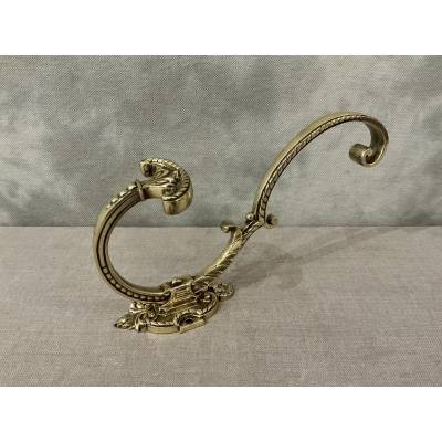 Polished and varnished bronze coat hook from the 19th century
