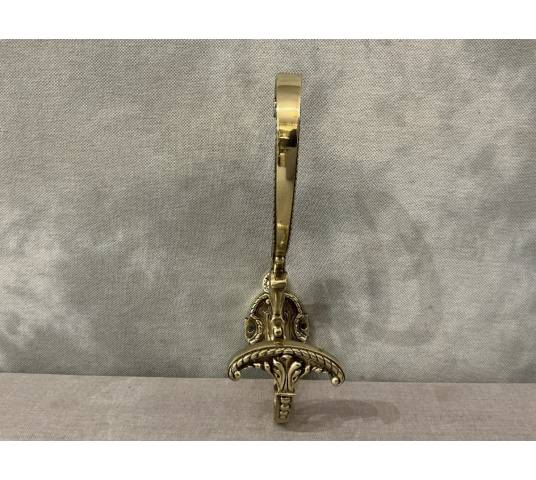 Polished and varnished bronze coat hook from the 19th century