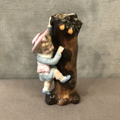 A little girl climbing to the trunk of a 19th-century porcelain tree