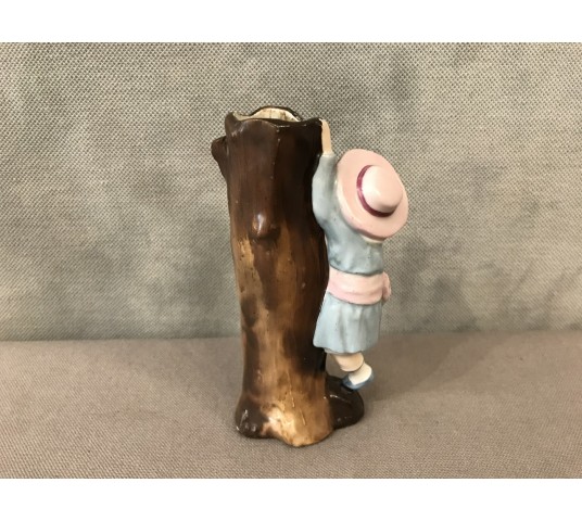 A little girl climbing to the trunk of a 19th-century porcelain tree