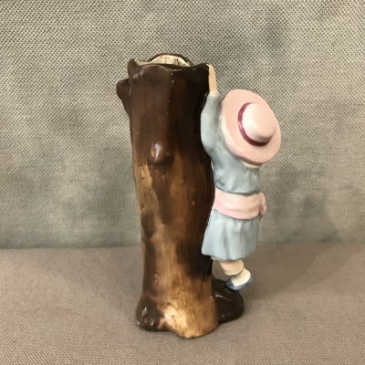 A little girl climbing to the trunk of a 19th-century porcelain tree