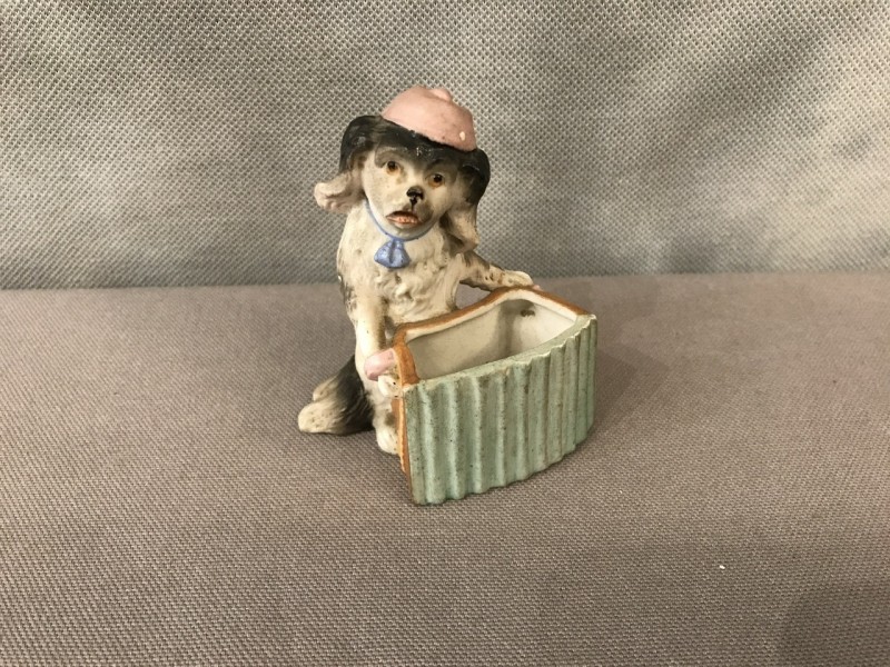 Petit chien en porcelaine au bras armé d’époque 19ème