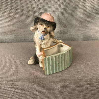 Petit chien en porcelaine au bras armé d’époque 19ème