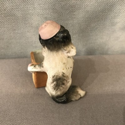 Small porcelain dog in the armed arm of the period 19ème