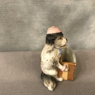 Petit chien en porcelaine au bras armé d’époque 19ème