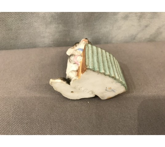 Petit chien en porcelaine au bras armé d’époque 19ème